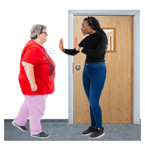 A person is being stopped from leaving their home by a member of staff.